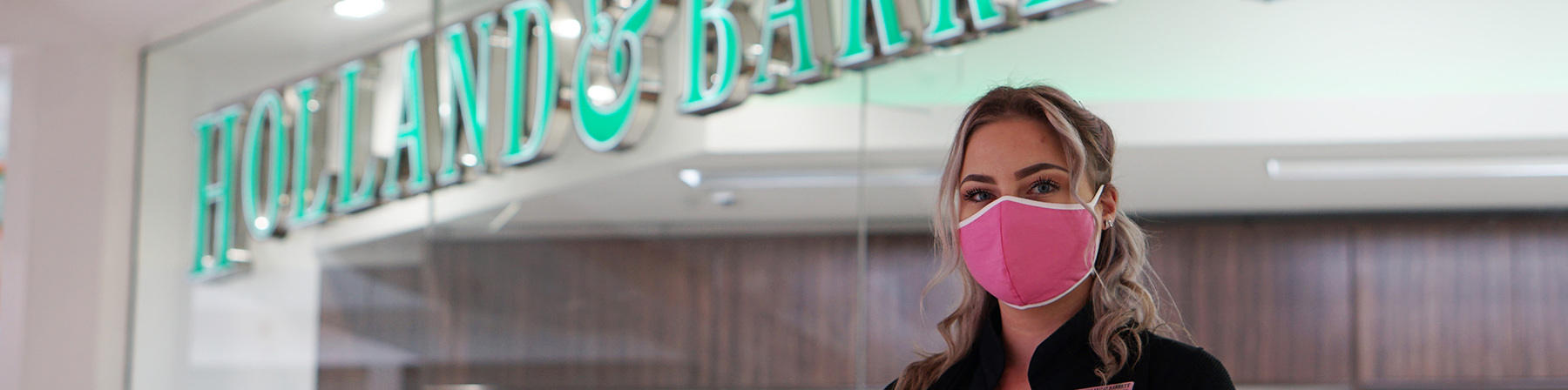 Masked employee outside Holland & Barrett