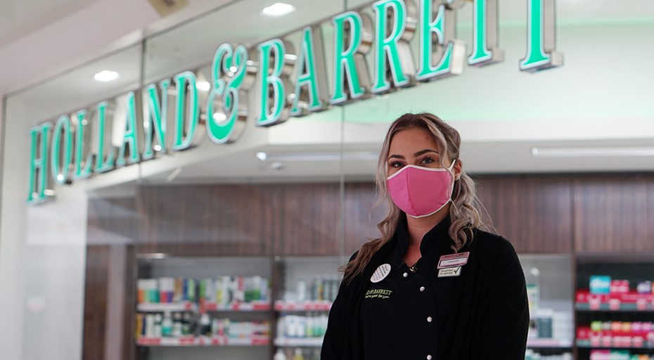 Masked employee outside Holland & Barrett